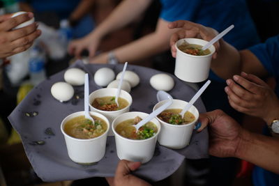 Midsection of people eating food on table