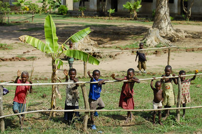 People standing on field by fence