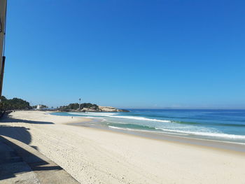 Scenic view of beach against clear blue sky