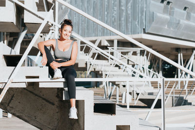 Full length of young woman standing on staircase