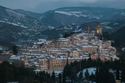 Aerial view of townscape by mountains during winter