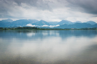 Scenic view of lake by mountains against sky