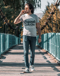 Full length of man standing on footbridge