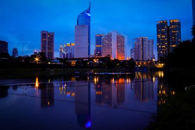 Reflection of illuminated buildings in city at dusk