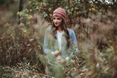 Young woman standing amidst plants