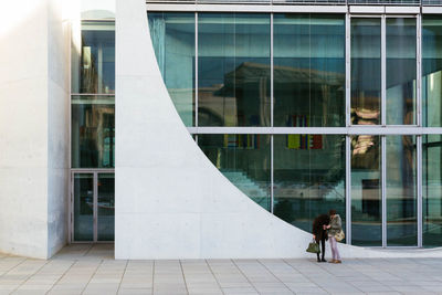 Reflection of woman on window of building