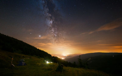 Scenic view of illuminated mountains against sky at night