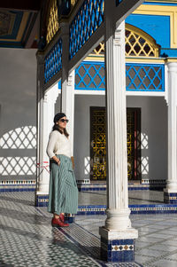 Full length portrait of young woman standing in city