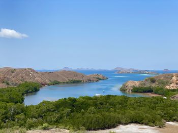 Scenic view of sea and mountains against blue sky