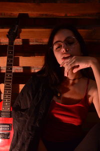 Portrait of beautiful young woman sitting in darkroom