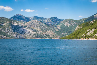 Scenic view of sea and mountains against sky