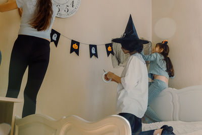 Portrait of female friends standing on bed