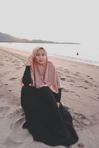 Portrait of young woman sitting on beach