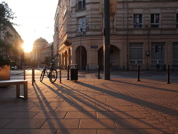 Footpath by street amidst buildings in city