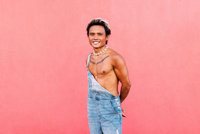 Portrait of gay person against pink background