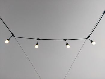 Low angle view of light bulbs hanging from ceiling