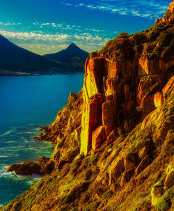 Rock formations by sea against sky