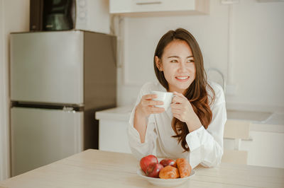 Young woman holding chocolate at home