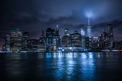 Illuminated buildings in city against sky at night