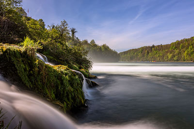 Scenic view of waterfall against sky