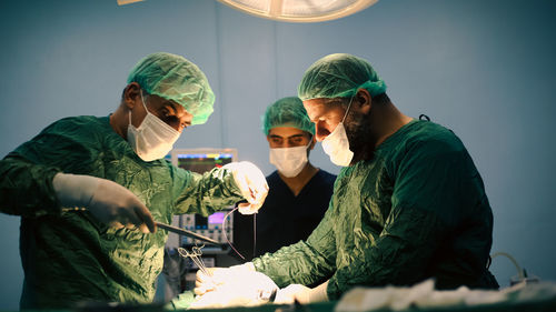 Medical team of surgeons in hospital doing minimal invasive surgical interventions. 