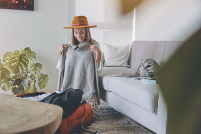 Portrait of young woman sitting on sofa at home