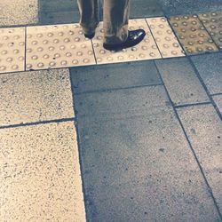 Low section of man walking on road