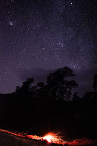 Firework display over mountain against sky at night