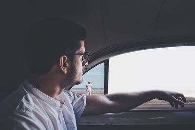 Man looking at view while sitting in car