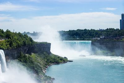 Scenic view of waterfall against sky