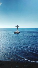 Sunken cemetery in sea against blue sky