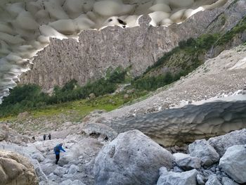 Rear view of man on rocks against mountains