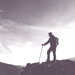 Full length of silhouette man standing on rock against sky