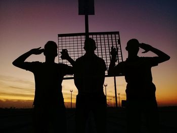 Silhouette people standing against sky during sunset