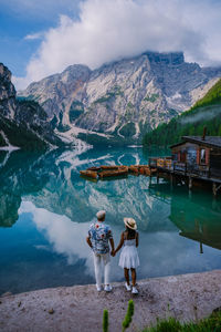 Rear view of women on lake against mountains