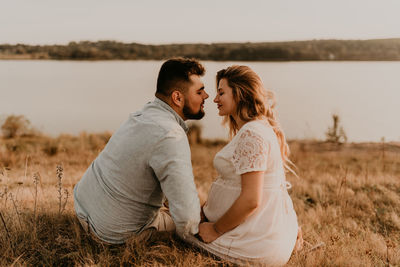 Side view of couple standing on field