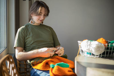 Portrait of young woman sitting on sofa at home