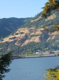 Scenic view of river by mountains against sky