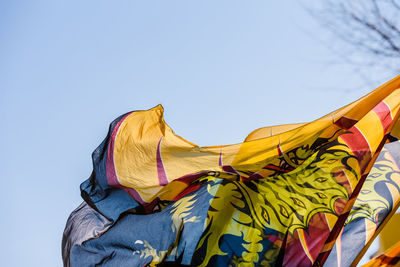 Low angle view of multi colored umbrella against clear blue sky