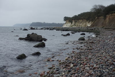 Rocks on beach against sky