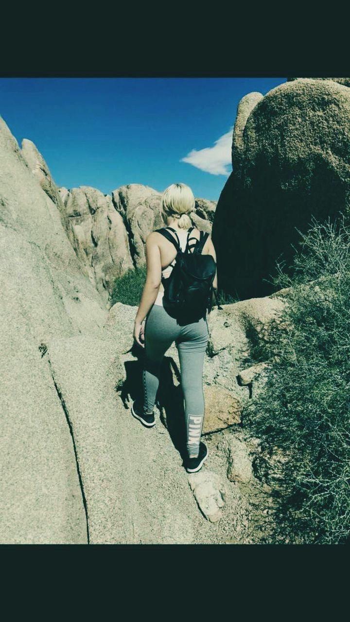 full length, one person, real people, rock, lifestyles, leisure activity, rock - object, solid, day, nature, sky, sitting, sunlight, auto post production filter, young women, relaxation, young adult, outdoors, shadow