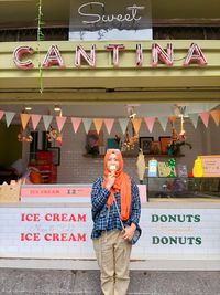 Full length of man standing against graffiti wall