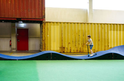 Boy riding a scooter indoor