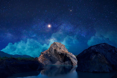 Scenic view of mountains against sky at night