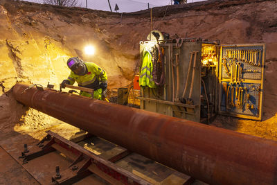 Worker preparing pipe at construction site