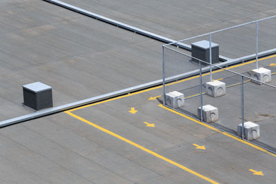 High angle view of arrow symbol on road by fence