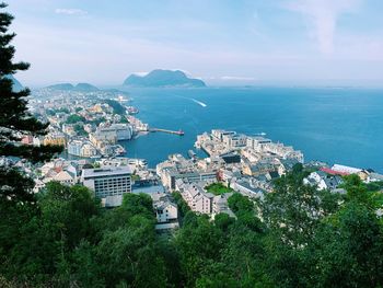 High angle view of townscape by sea against sky