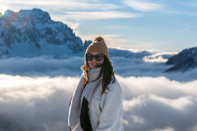 Portrait of woman in front of amazing alpine landscape with snow capped mountains