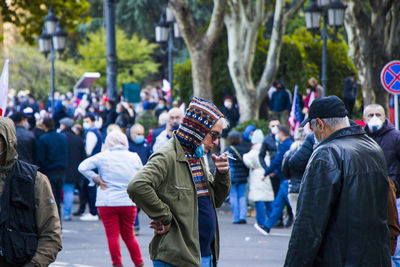 Rear view of people walking on street in city