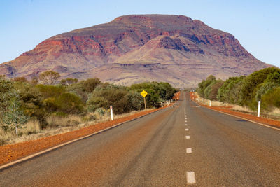 Road by mountain against sky